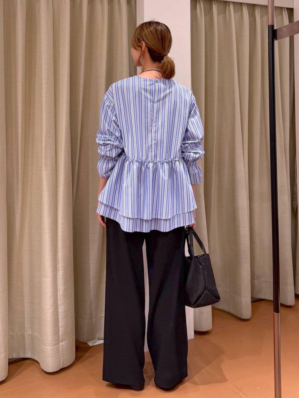 ブラック系のその他パンツ、ブラック系のパンプス、ブルー系のシャツ/ブラウスを着用したレディースの春コーディネートの4枚目の写真