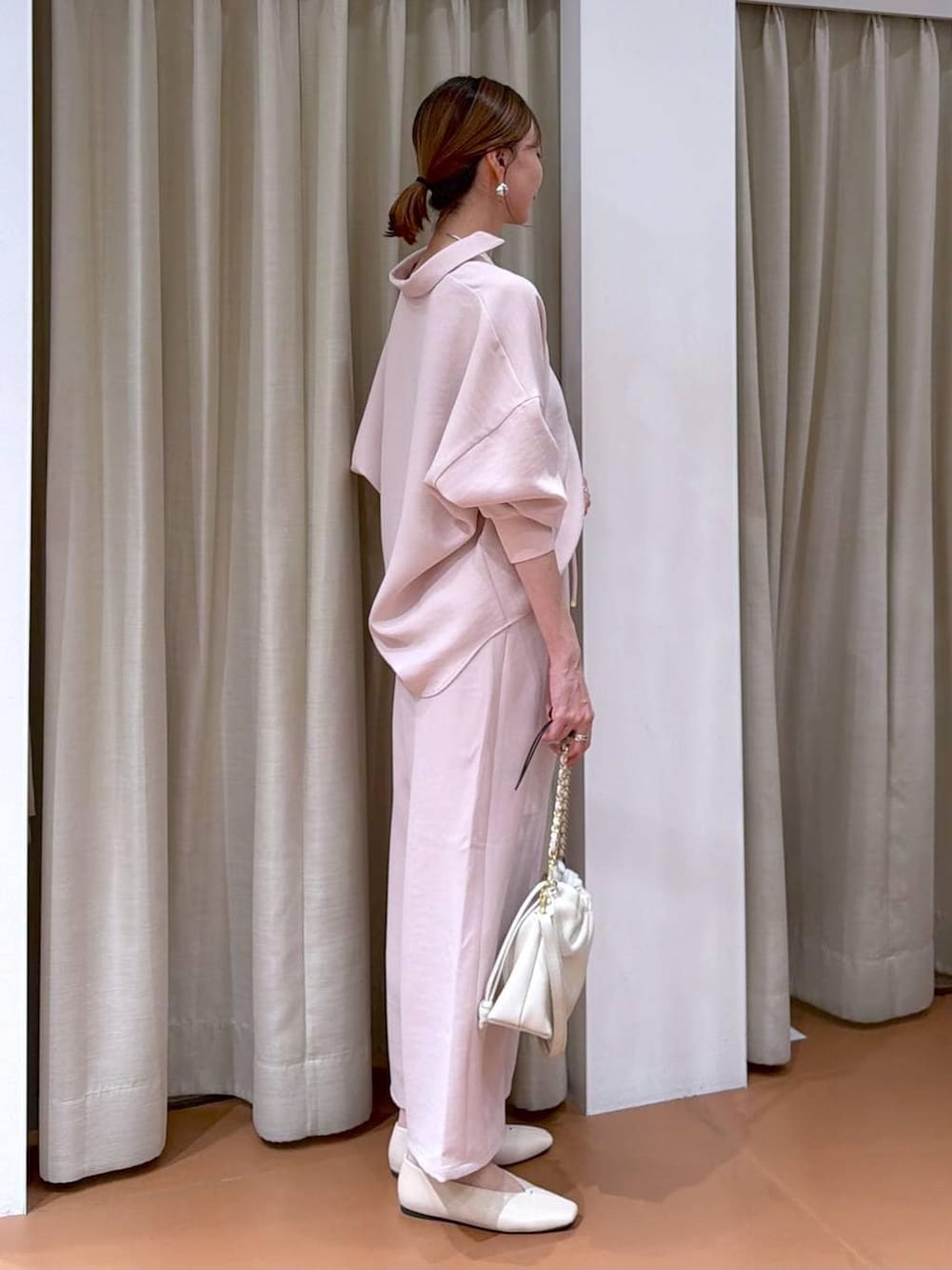 ホワイト系のハンドバッグ、ホワイト系のパンプス、ピンク系のその他パンツを着用したレディースの冬コーディネートの5枚目の写真