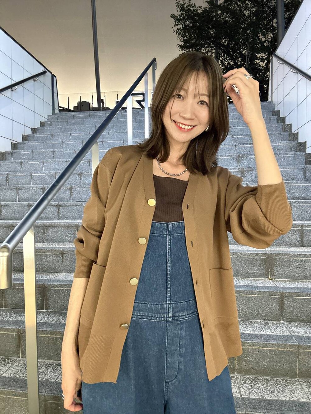 ブラウン系のニット/セーター、ブラウン系のカーディガン/ボレロ、ブルー系のサロペット/オーバーオールを着用したレディースの夏コーディネートの9枚目の写真