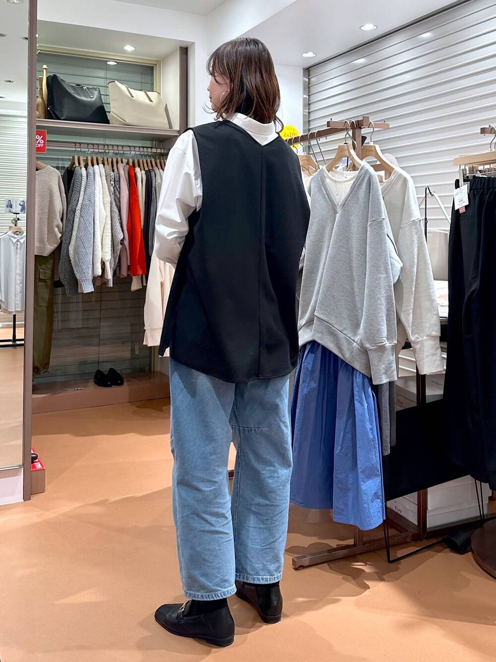 イエロー系のハンドバッグ、ホワイト系のシャツ/ブラウス、ブラック系のローファーを着用したレディースの冬コーディネートの4枚目の写真