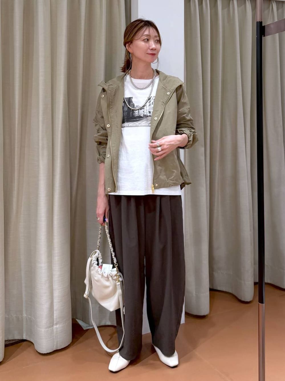 ホワイト系のハンドバッグ、ホワイト系のパンプス、ピンク系のその他パンツを着用したレディースの春コーディネートの2枚目の写真