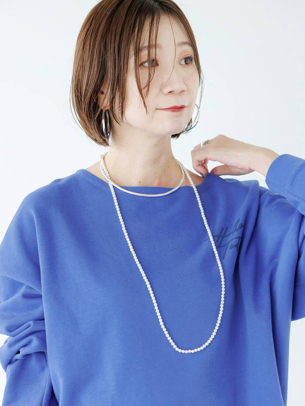 シルバー系のローファー、ブルー系のデニムパンツを着用したレディースの秋コーディネートの10枚目の写真