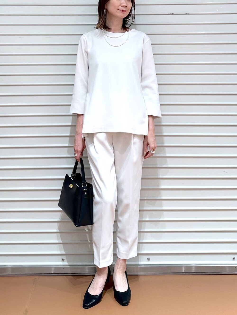 ベージュ系のその他パンツ、ベージュ系のシャツ/ブラウス、ブラック系のハンドバッグを着用したレディースの冬コーディネートの5枚目の写真