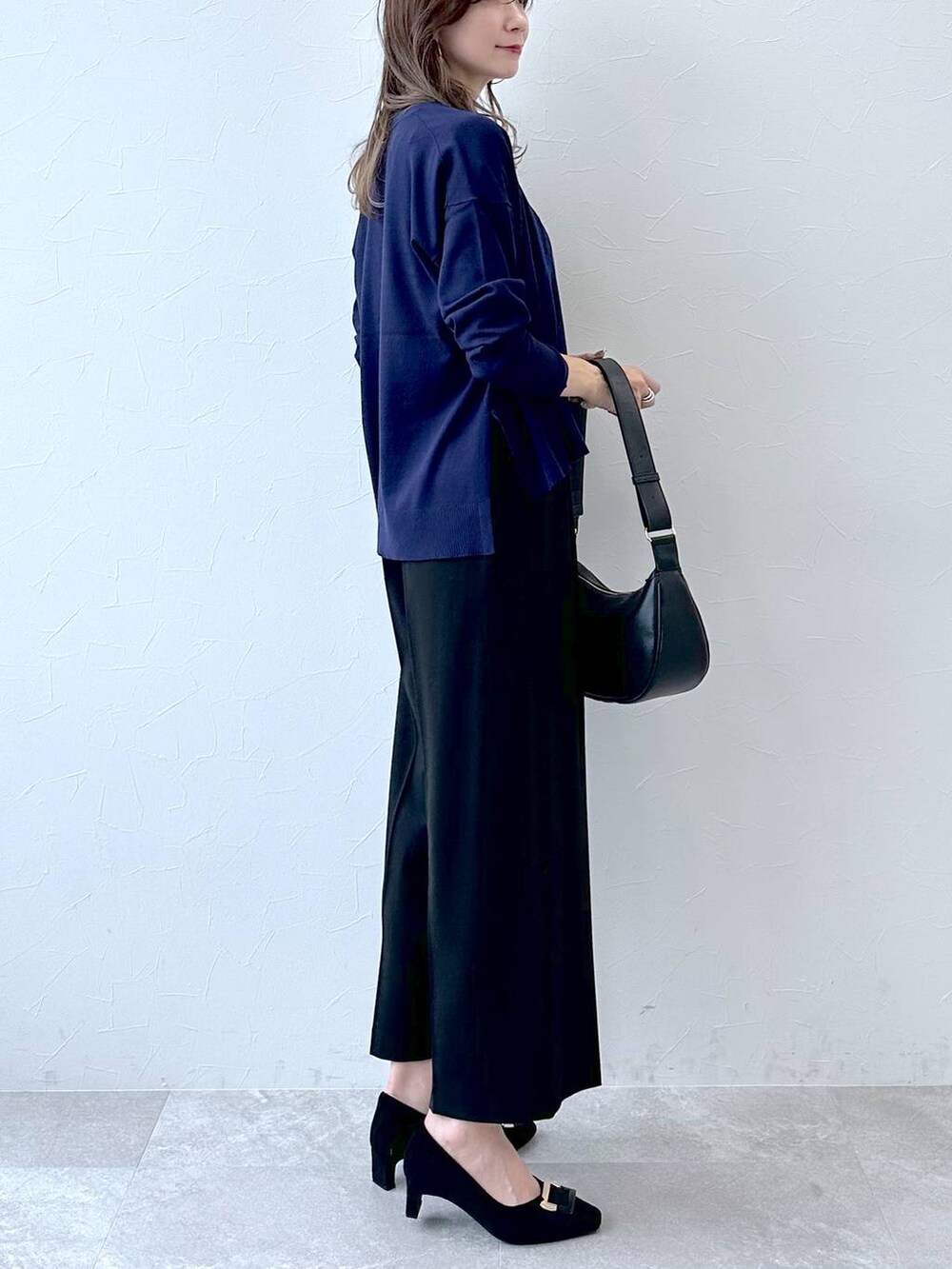 グレー系のパンプス、ブルー系のその他パンツ、ブラック系のハンドバッグを着用したレディースの冬コーディネートの6枚目の写真