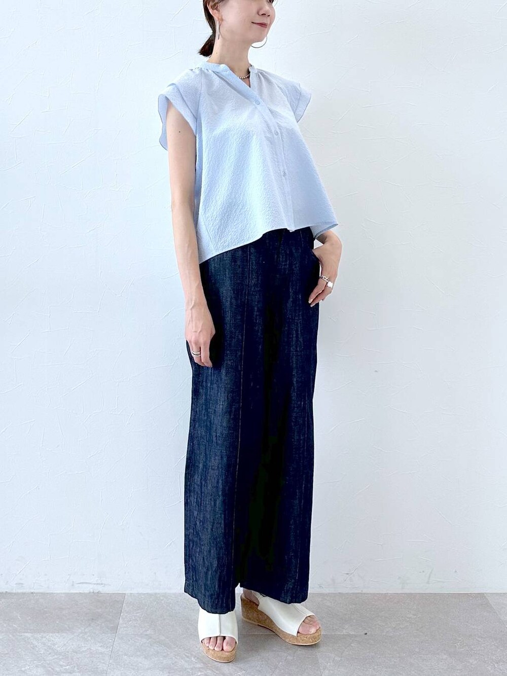 ブルー系のデニムパンツ、ブルー系のデニムパンツ、ホワイト系のサンダルを着用したレディースの夏コーディネートの5枚目の写真