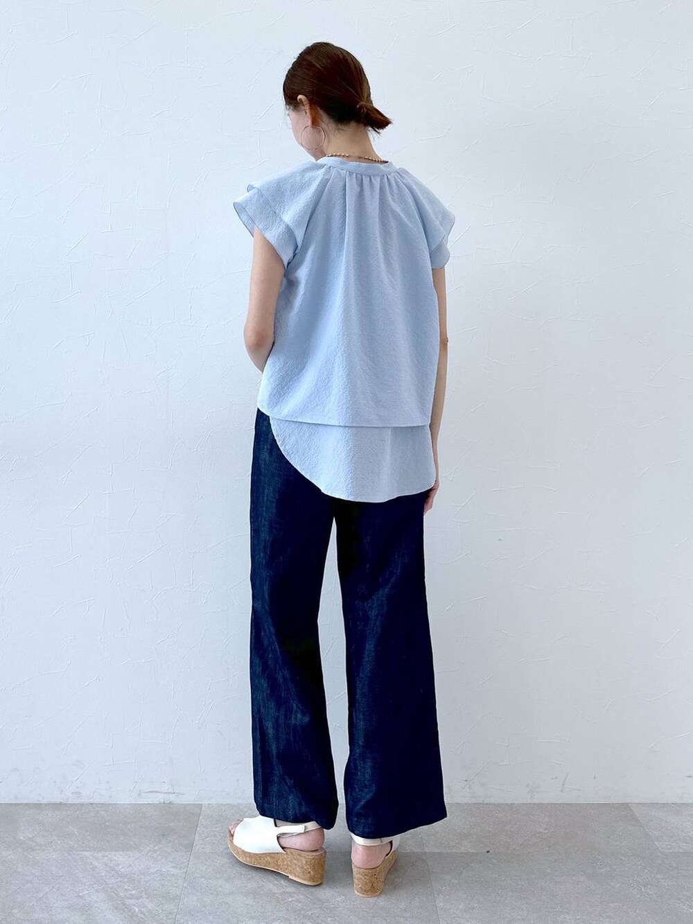 ブルー系のデニムパンツ、ブルー系のデニムパンツ、ホワイト系のサンダルを着用したレディースの夏コーディネートの4枚目の写真