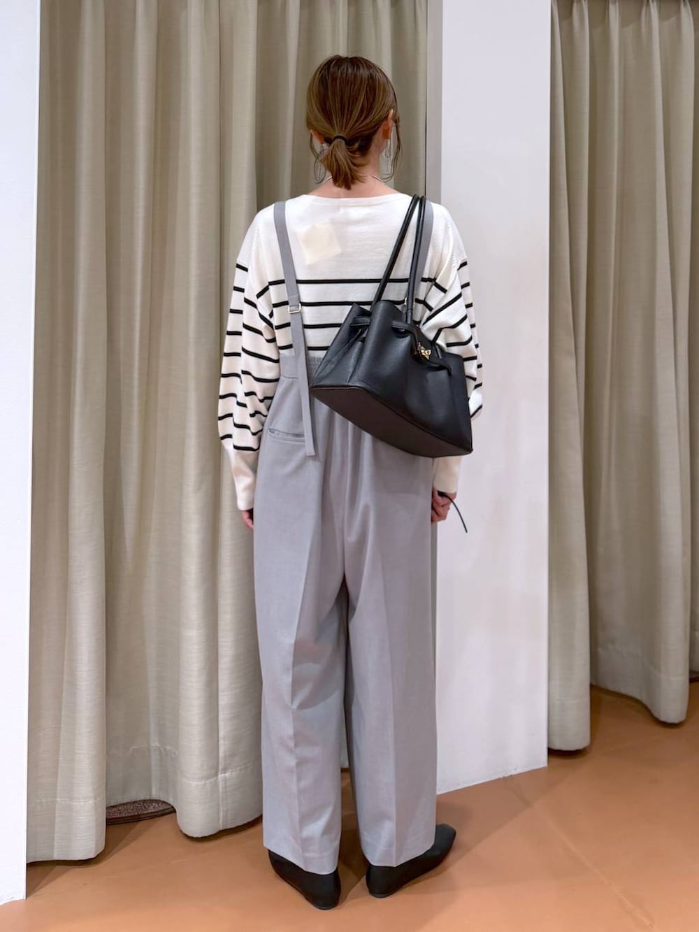 ホワイト系のニット/セーター、ブラック系のパンプス、ブラック系のハンドバッグを着用したレディースの冬コーディネートの4枚目の写真