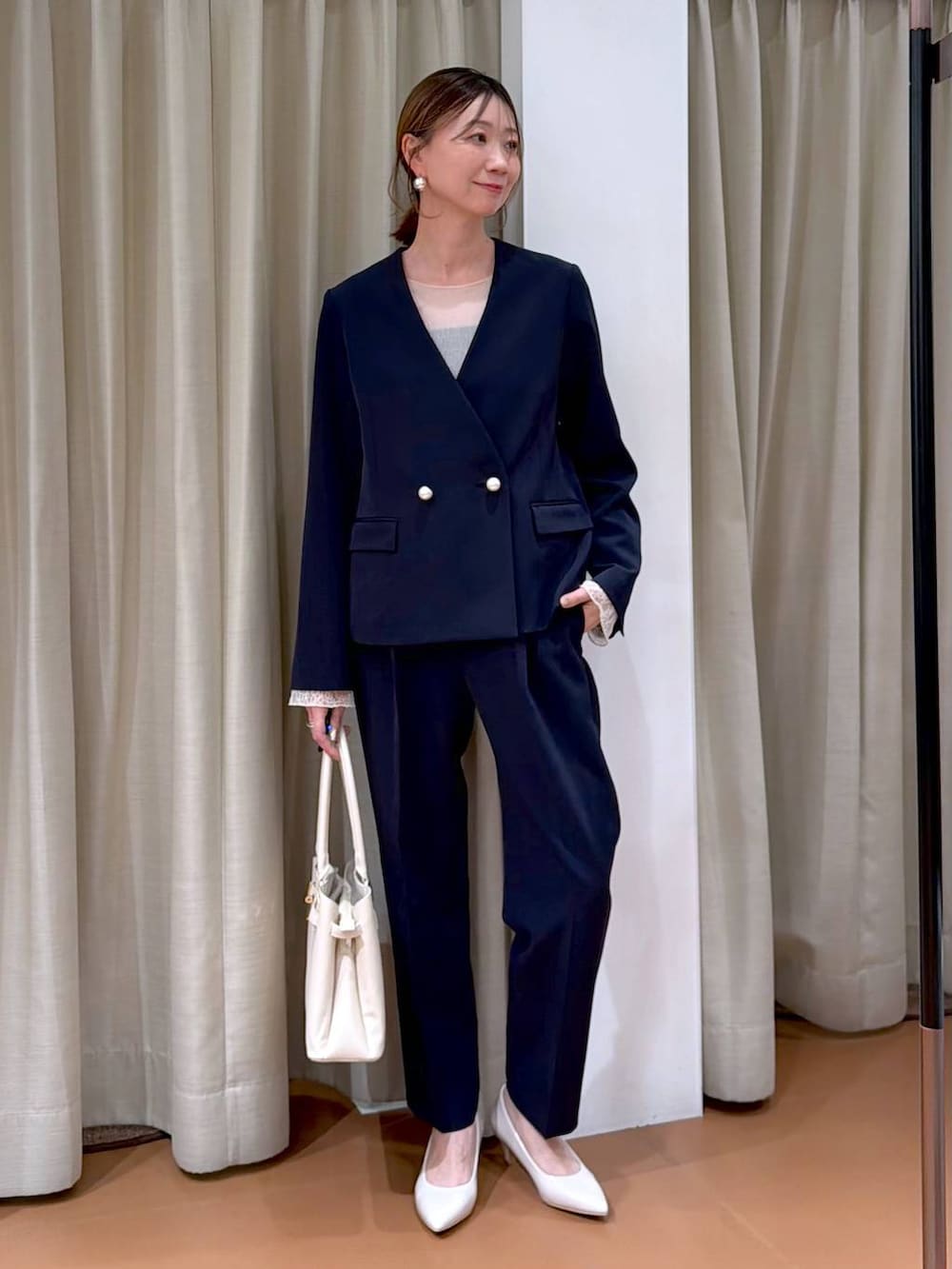 ホワイト系のパンプス、ホワイト系のTシャツ/カットソー、ブルー系のノーカラージャケットを着用したレディースの冬コーディネートの2枚目の写真