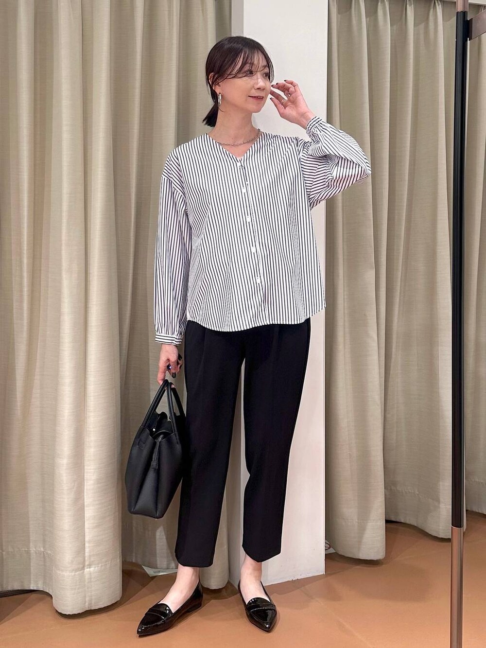 ブラック系のその他パンツ、ブルー系のシャツ/ブラウス、ブラック系のハンドバッグを着用したレディースの春コーディネートの2枚目の写真
