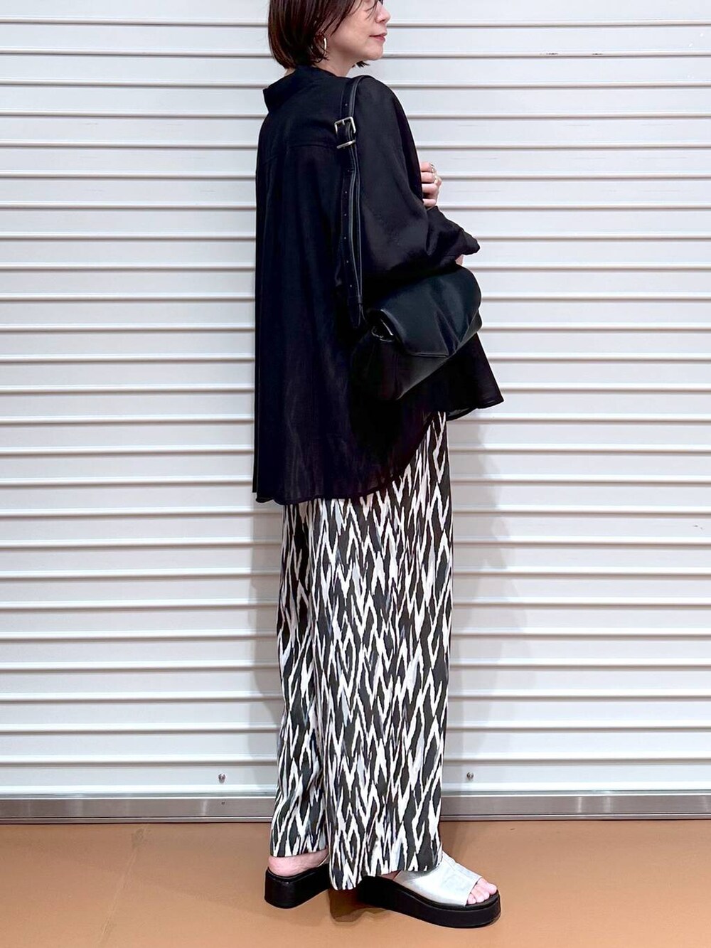 ブラック系のシャツ/ブラウス、シルバー系のサンダル、ブラック系のその他パンツを着用したレディースの夏コーディネートの6枚目の写真