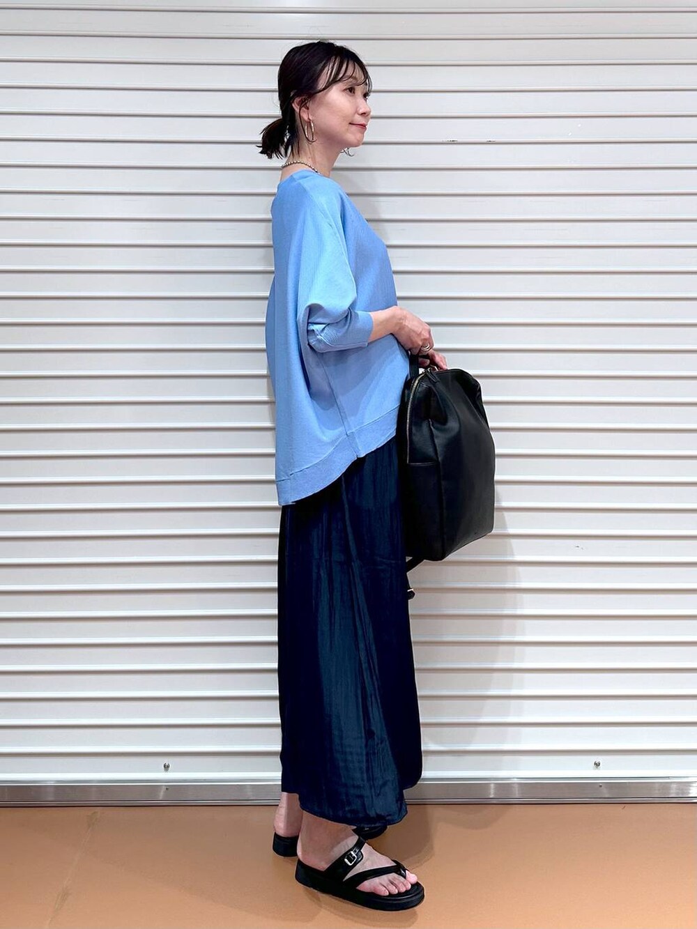 ブルー系のニット/セーター、ブラック系のバックパック/リュック、ブルー系のその他パンツを着用したレディースの夏コーディネートの6枚目の写真