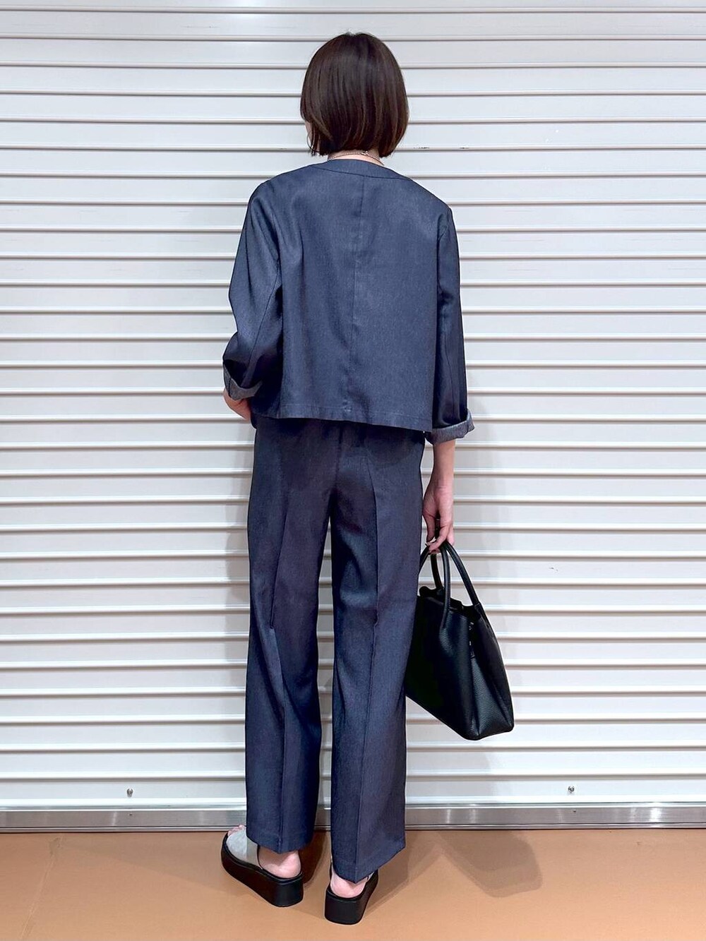 ブラック系のハンドバッグ、シルバー系のサンダル、ブラウン系のタンクトップを着用したレディースの夏コーディネートの4枚目の写真