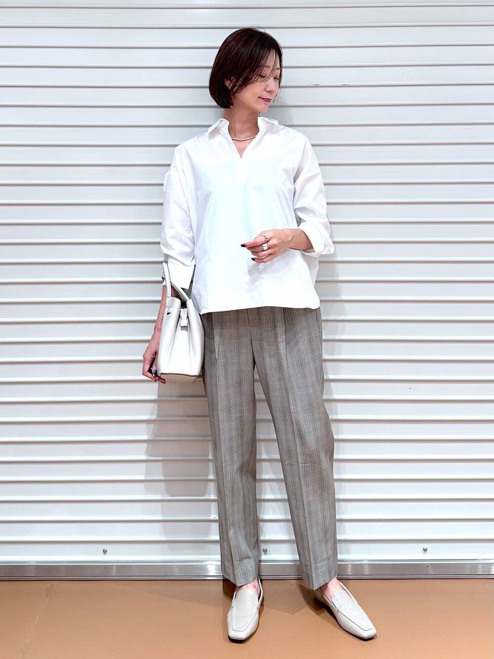 ブラウン系のその他パンツ、グレー系のハンドバッグ、ホワイト系のシャツ/ブラウスを着用したレディースの秋コーディネートの2枚目の写真