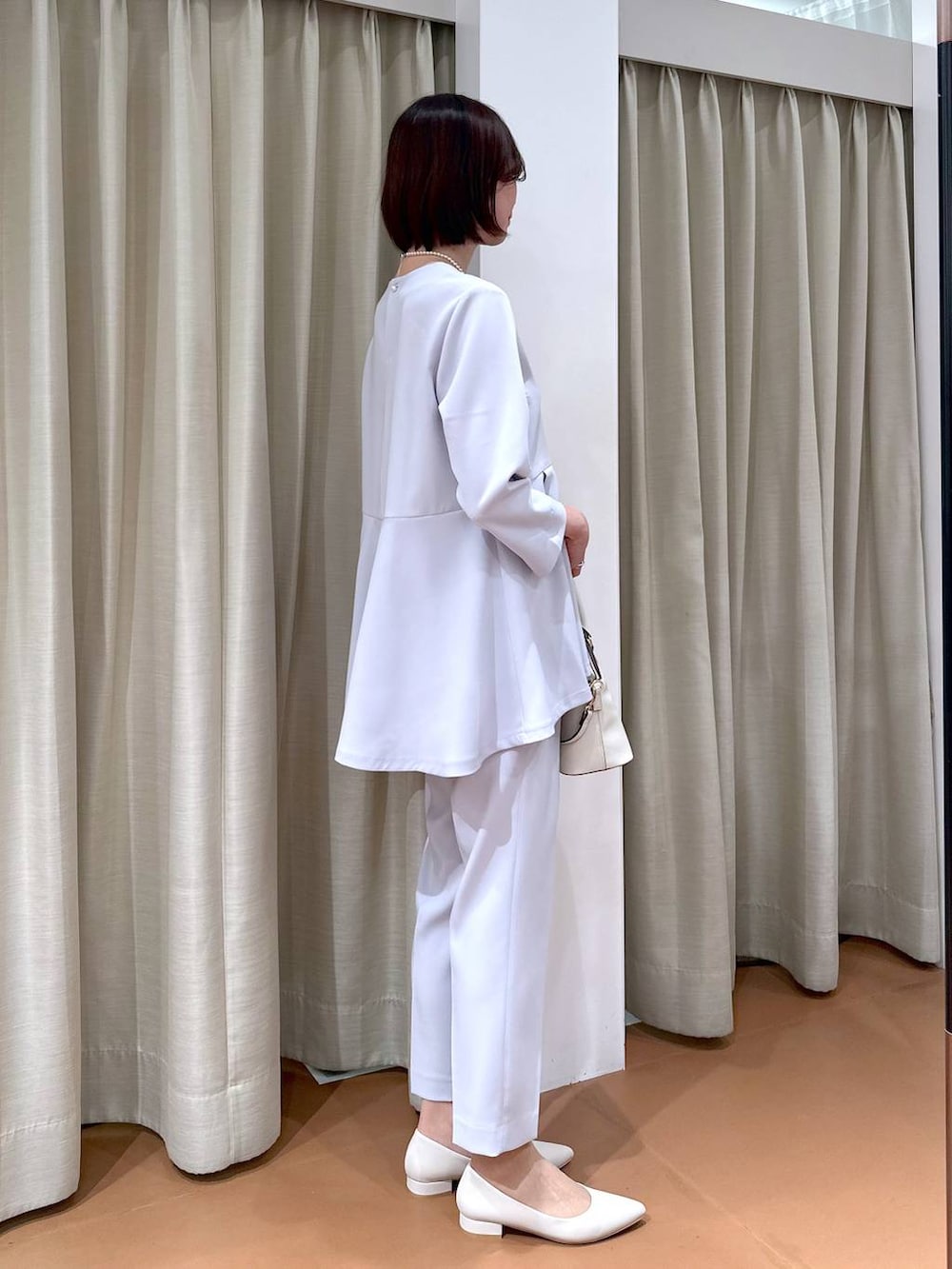 ブルー系のスーツパンツ、ブルー系のシャツ/ブラウス、ホワイト系のハンドバッグを着用したレディースの冬コーディネートの5枚目の写真