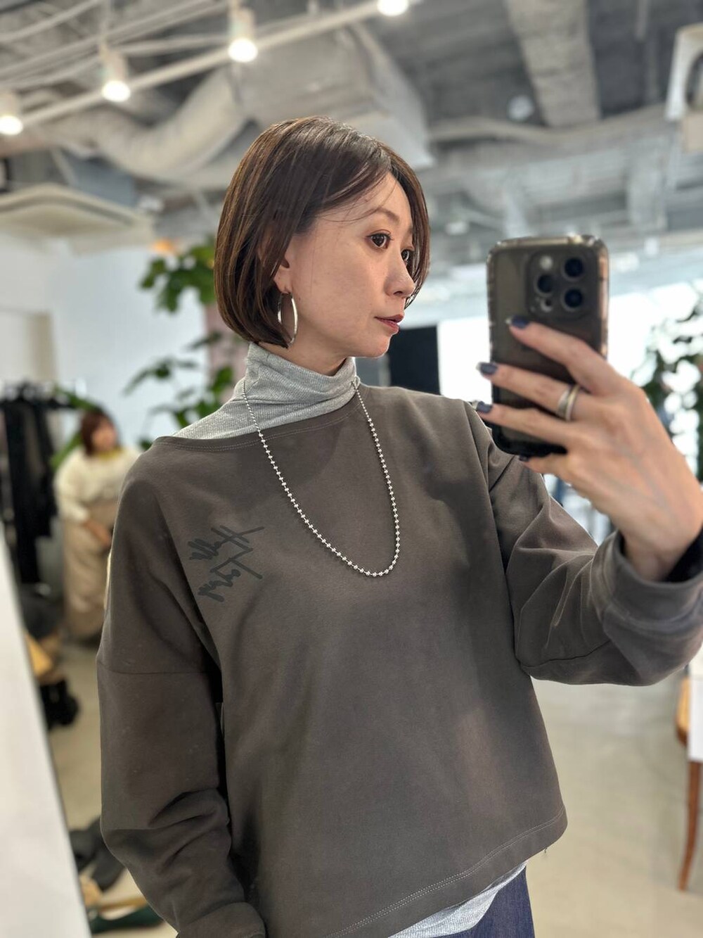 ブラウン系のパンプス、ブルー系のデニムパンツ、シルバー系のネックレスを着用したレディースの夏コーディネートの6枚目の写真