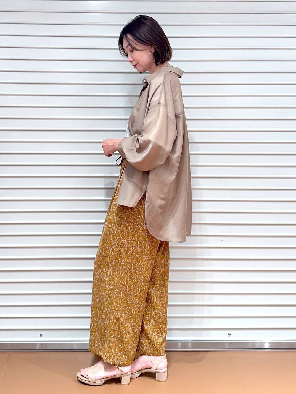 ベージュ系のサンダル、ブラウン系のその他パンツ、ホワイト系のTシャツ/カットソーを着用したレディースの秋コーディネートの3枚目の写真