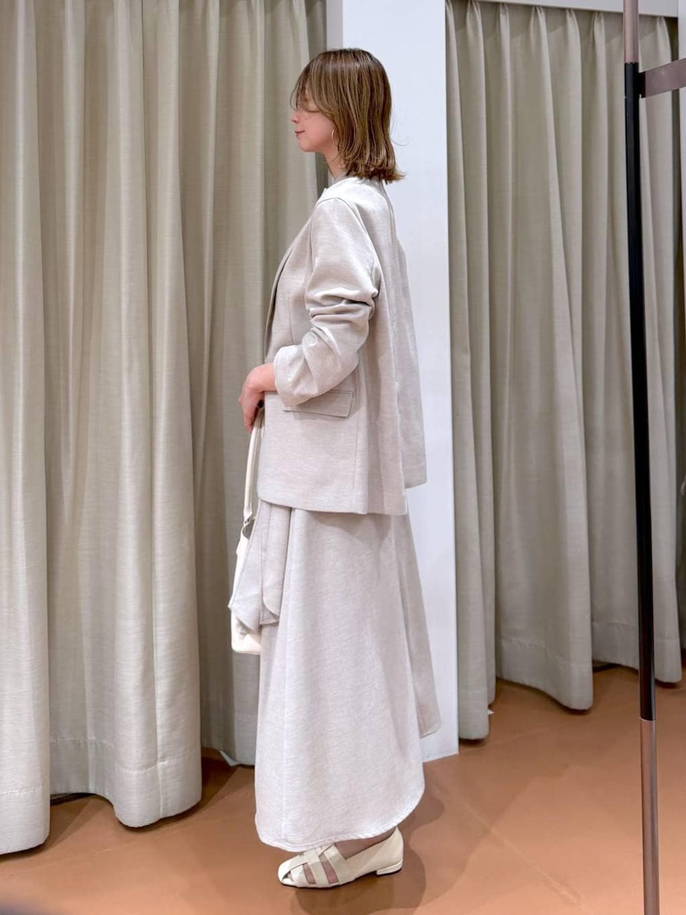 ホワイト系のハンドバッグ、ホワイト系のパンプス、ホワイト系のTシャツ/カットソーを着用したレディースの春コーディネートの5枚目の写真