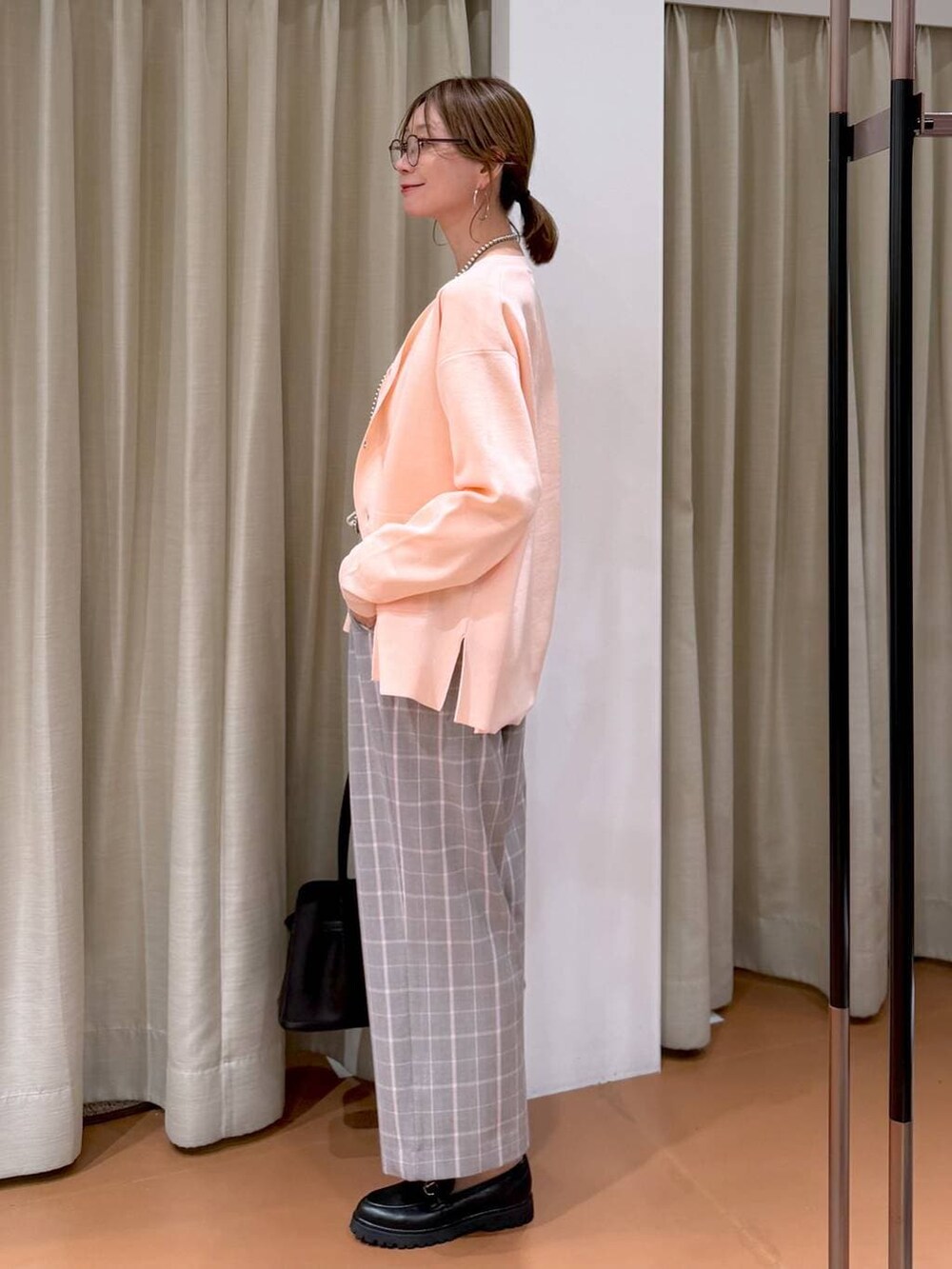 ピンク系のカーディガン/ボレロ、ブラック系のローファー、ブラック系のハンドバッグを着用したレディースの冬コーディネートの5枚目の写真