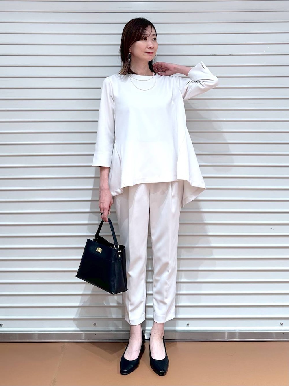 ベージュ系のその他パンツ、ベージュ系のシャツ/ブラウス、ブラック系のハンドバッグを着用したレディースの冬コーディネートの2枚目の写真