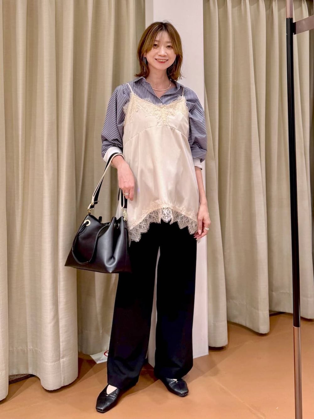 ブラック系のその他パンツ、ブラック系のパンプス、ホワイト系のキャミソールを着用したレディースの春コーディネートの6枚目の写真