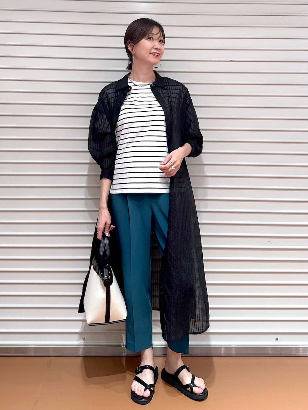 グリーン系のその他パンツ、ブラック系のサンダル、ブラック系のTシャツ/カットソーを着用したレディースの夏コーディネートの2枚目の写真