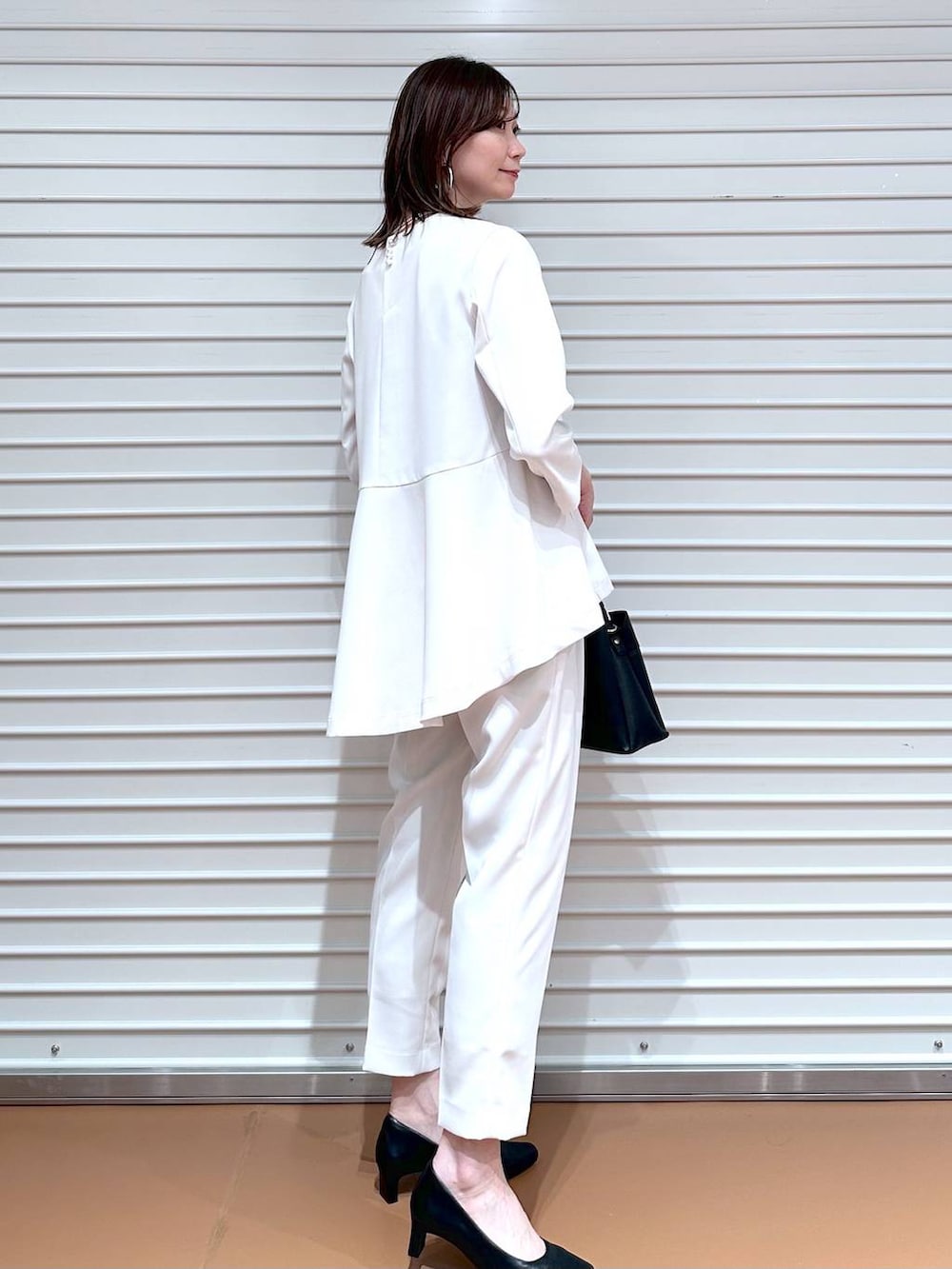 ベージュ系のその他パンツ、ベージュ系のシャツ/ブラウス、ブラック系のハンドバッグを着用したレディースの冬コーディネートの4枚目の写真