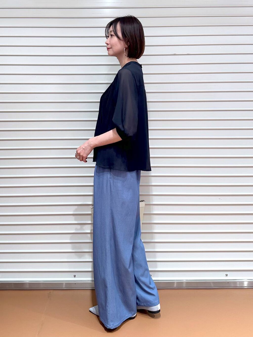 シルバー系のパンプス、ブルー系のシャツ/ブラウス、ブルー系のデニムパンツを着用したレディースの夏コーディネートの3枚目の写真