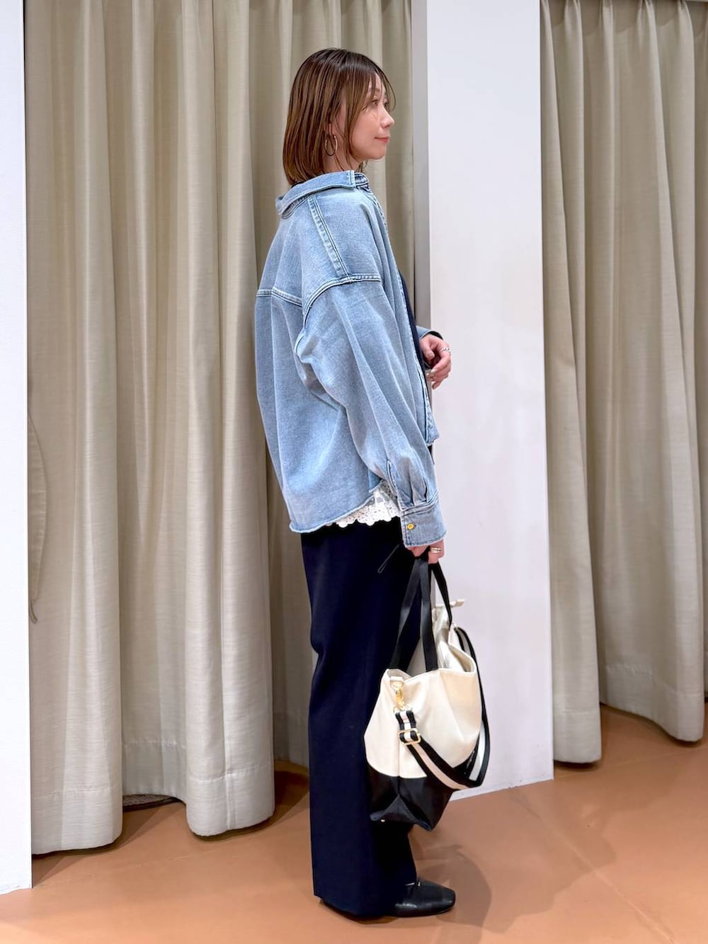 ベージュ系のトートバッグ、ブラック系のパンプス、ホワイト系のタンクトップを着用したレディースの冬コーディネートの5枚目の写真