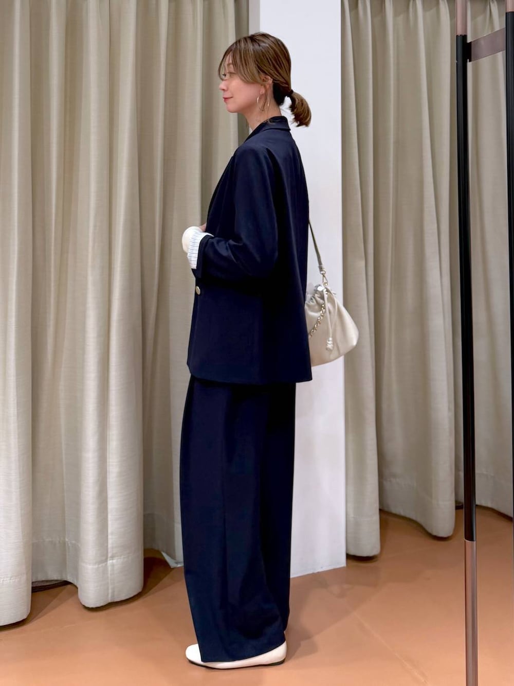 ホワイト系のハンドバッグ、ホワイト系のパンプス、ブルー系のその他パンツを着用したレディースの春コーディネートの3枚目の写真