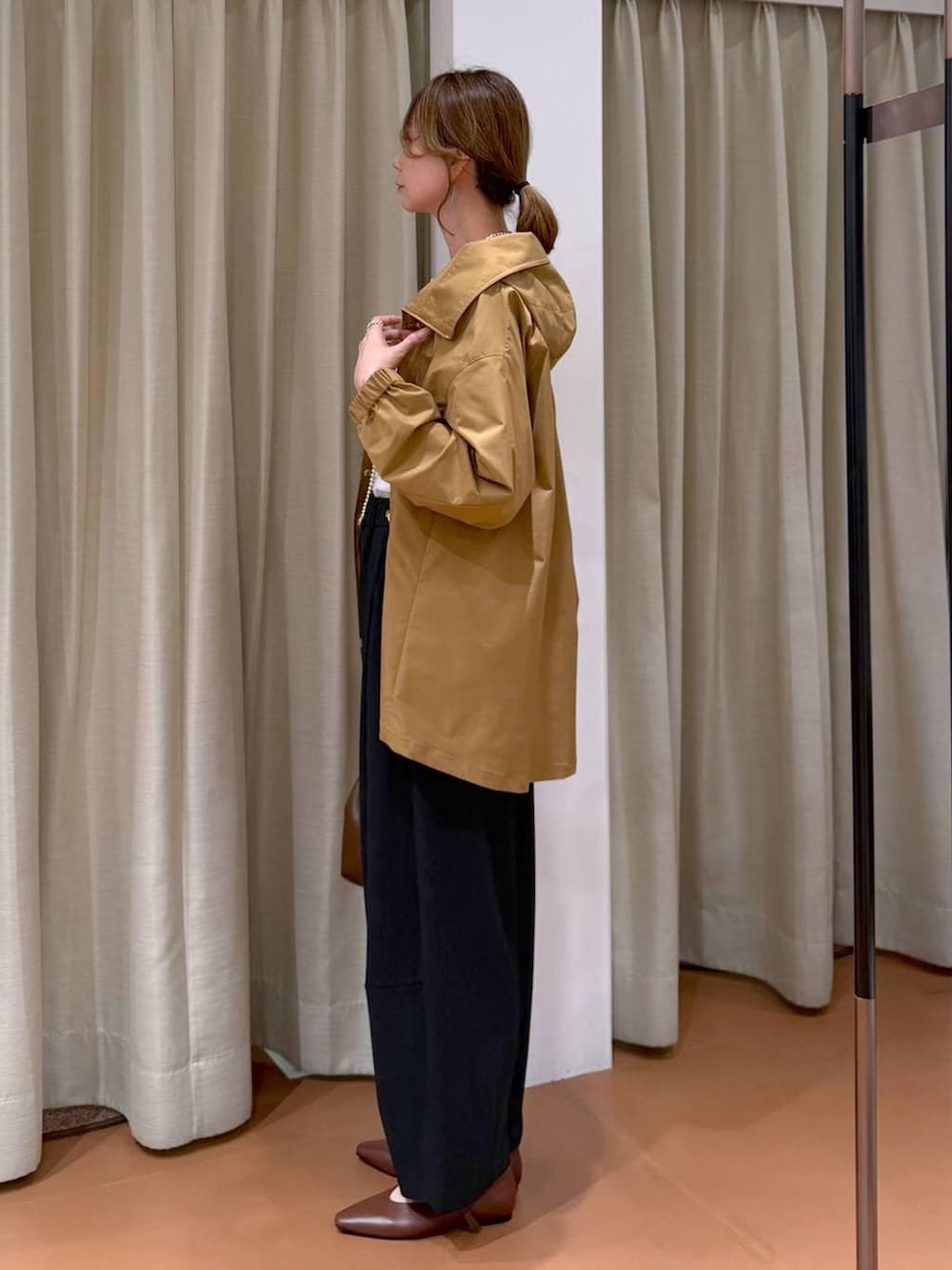 ブラック系のその他パンツ、ホワイト系のTシャツ/カットソー、イエロー系のマウンテンパーカーを着用したレディースの春コーディネートの3枚目の写真