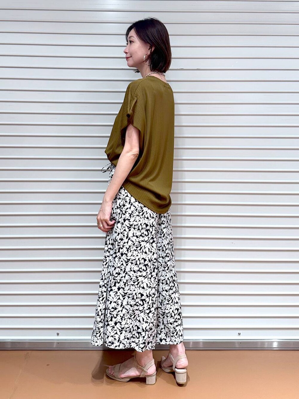 グリーン系のTシャツ/カットソー、ベージュ系のサンダル、ブラック系のその他パンツを着用したレディースの夏コーディネートの3枚目の写真