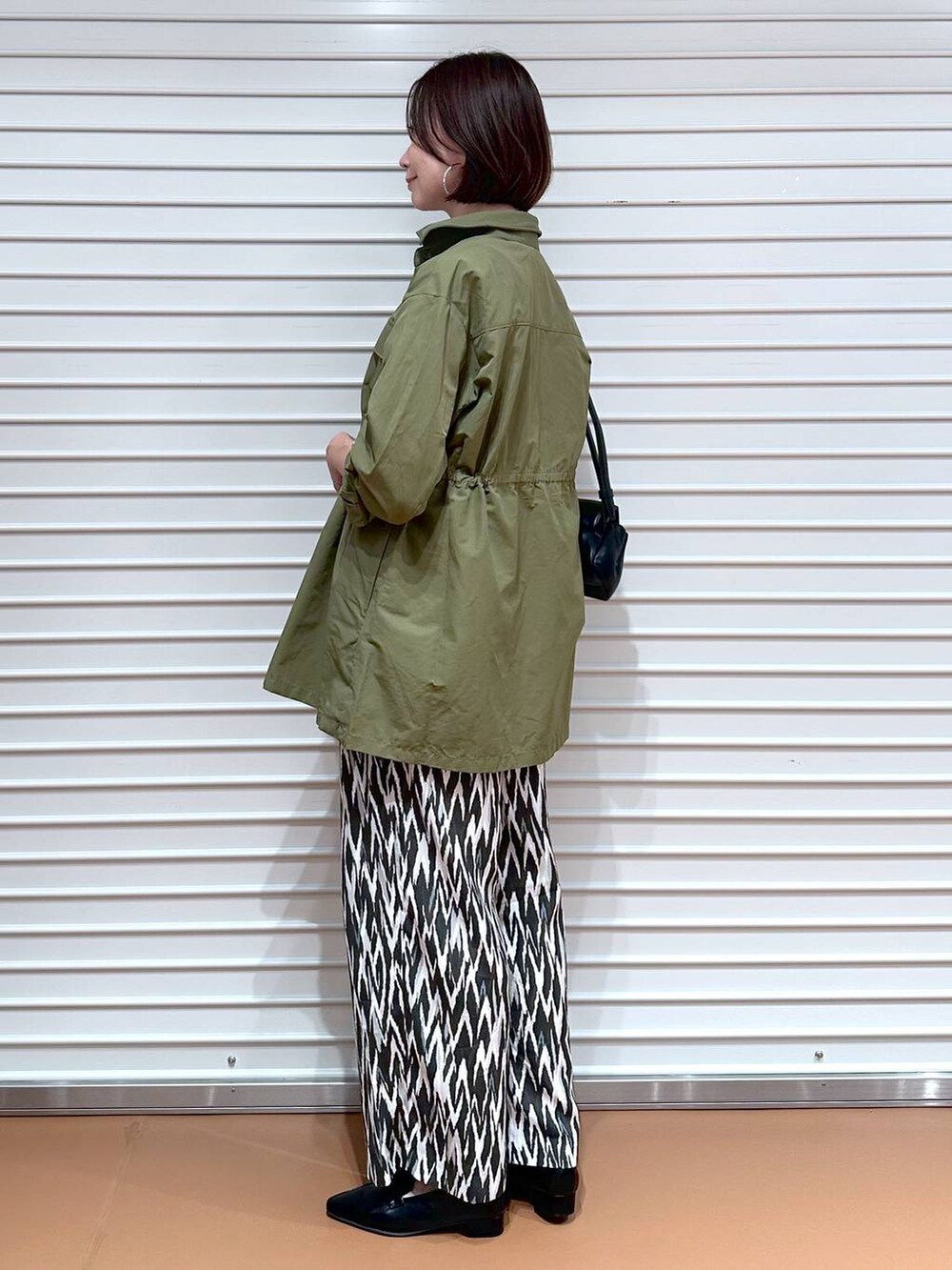 ブラック系のローファー、ホワイト系のTシャツ/カットソー、グリーン系のその他アウターを着用したレディースの秋コーディネートの3枚目の写真