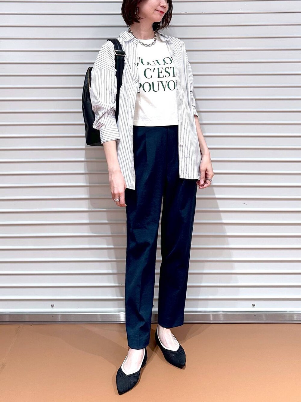 ブラック系のパンプス、ホワイト系のシャツ/ブラウス、ブラック系のバックパック/リュックを着用したレディースの春コーディネートの6枚目の写真