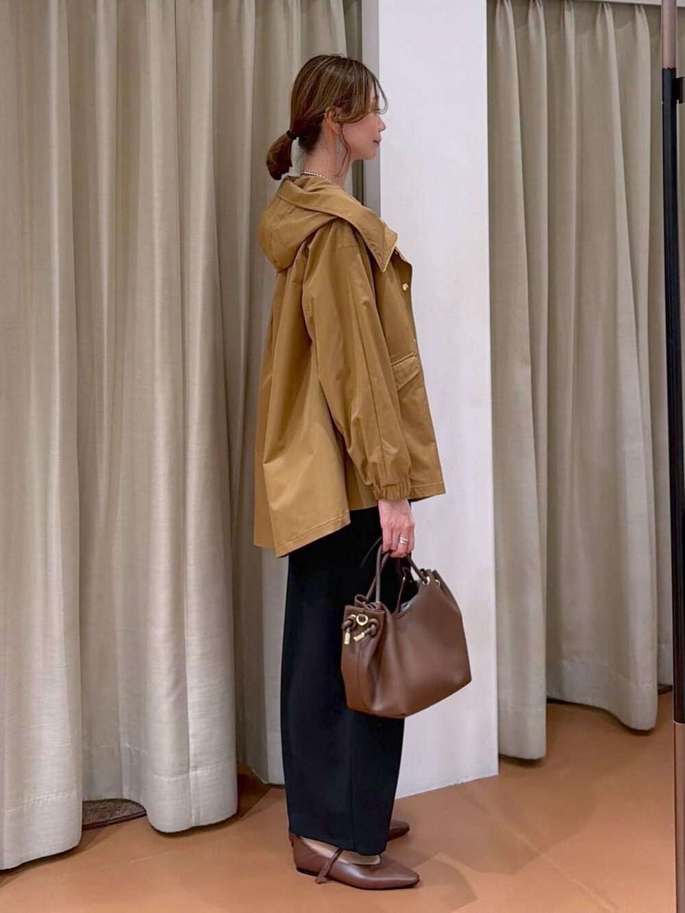 ブラック系のその他パンツ、ホワイト系のTシャツ/カットソー、イエロー系のマウンテンパーカーを着用したレディースの春コーディネートの5枚目の写真