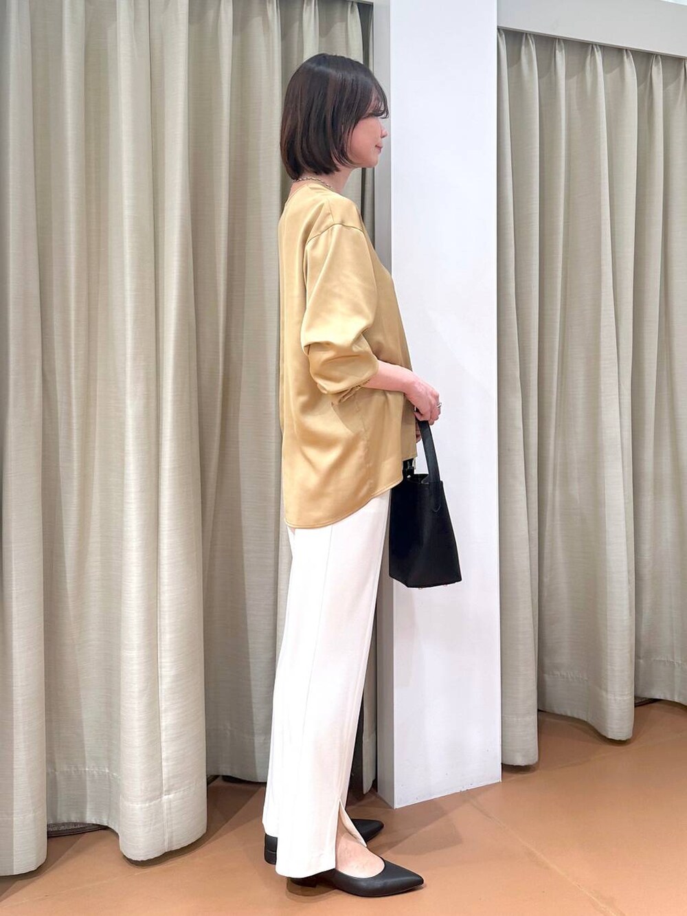 ホワイト系のその他パンツ、ブラウン系のシャツ/ブラウス、ブラック系のハンドバッグを着用したレディースの春コーディネートの3枚目の写真