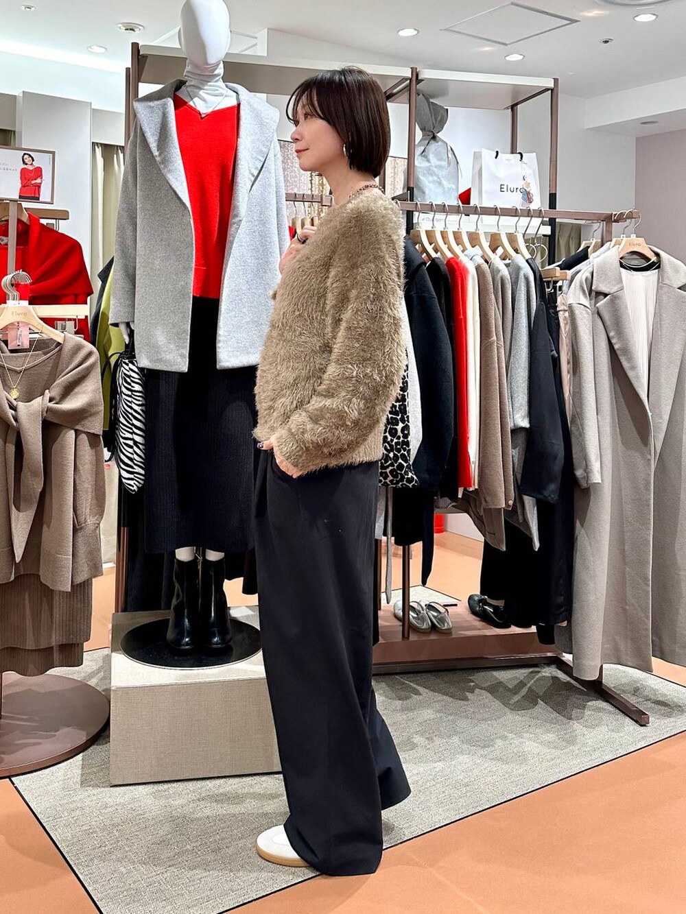 ブラック系のその他パンツ、ホワイト系のスニーカー、ブラウン系のニット/セーターを着用したレディースの冬コーディネートの5枚目の写真