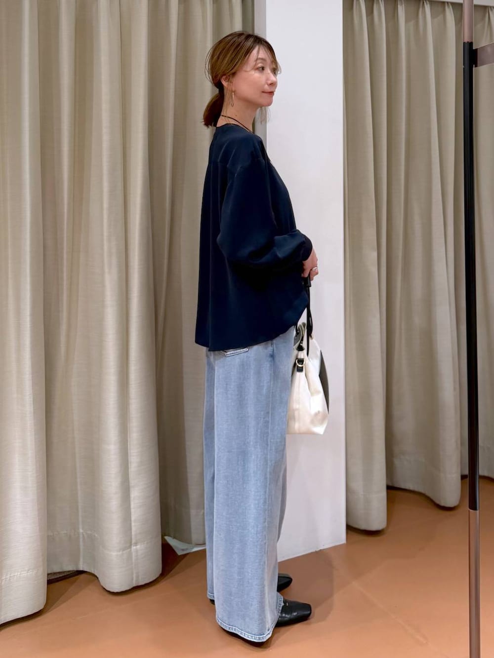 ホワイト系のパンプス、ブルー系のデニムパンツ、ホワイト系のトートバッグを着用したレディースの春コーディネートの5枚目の写真