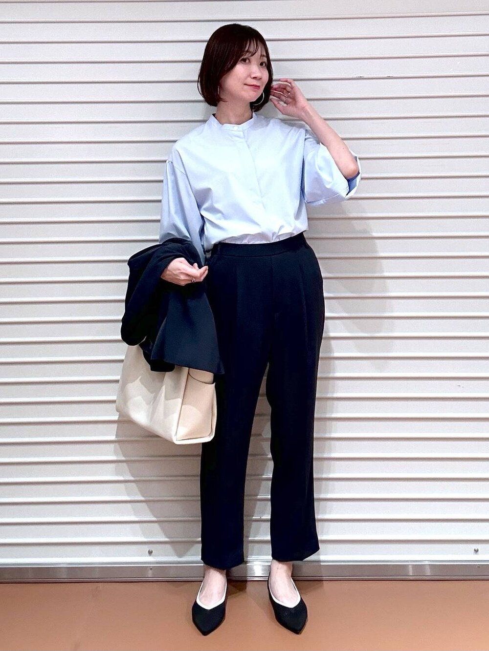 ブラック系のパンプス、ホワイト系のトートバッグ、ブルー系のその他パンツを着用したレディースの春コーディネートの4枚目の写真