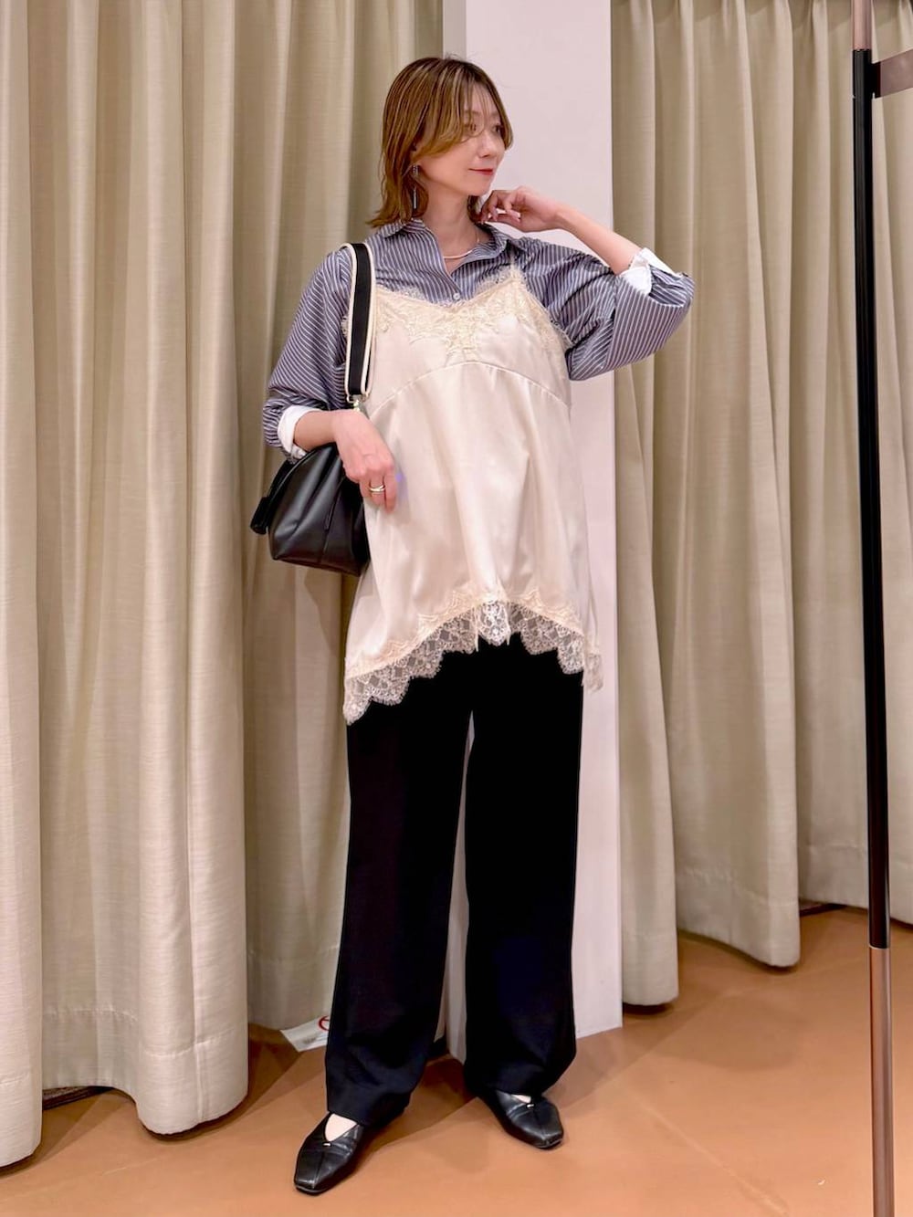 ブラック系のその他パンツ、ブラック系のパンプス、ホワイト系のキャミソールを着用したレディースの春コーディネートの2枚目の写真