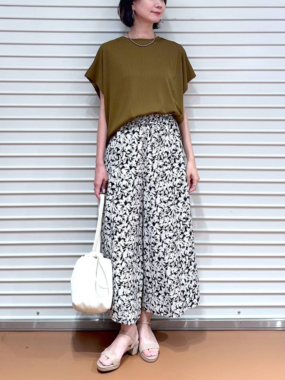 グリーン系のTシャツ/カットソー、ベージュ系のサンダル、ブラック系のその他パンツを着用したレディースの夏コーディネートの5枚目の写真