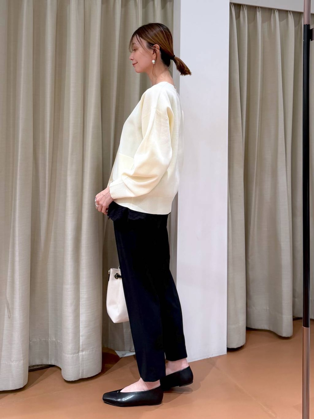 ブラック系のその他パンツ、ブラック系のパンプス、ホワイト系のトートバッグを着用したレディースの冬コーディネートの3枚目の写真