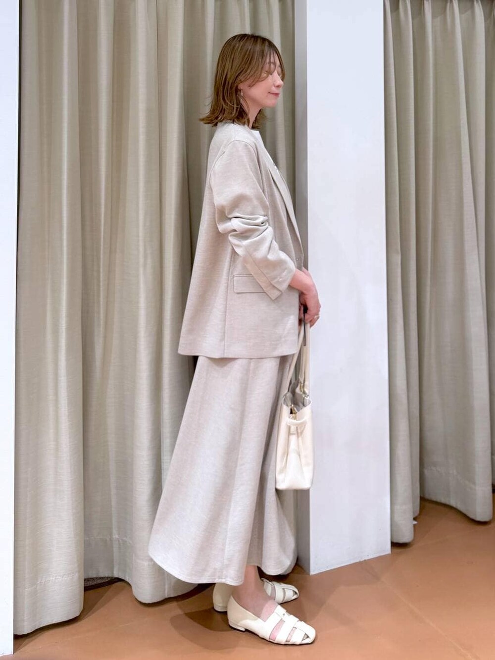 ホワイト系のハンドバッグ、ホワイト系のパンプス、ホワイト系のTシャツ/カットソーを着用したレディースの春コーディネートの3枚目の写真