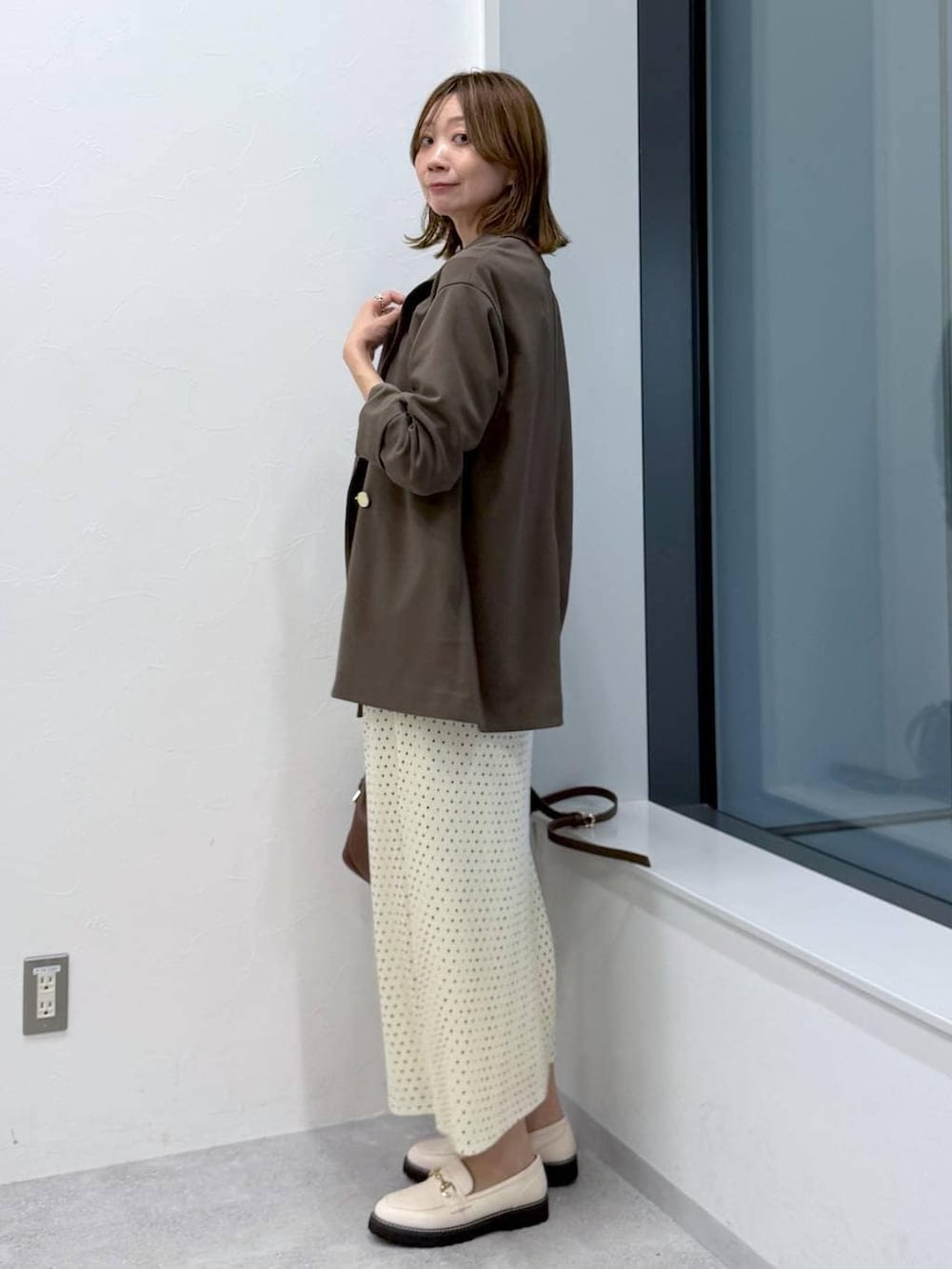 ホワイト系のスカート、ホワイト系のローファー、ホワイト系のTシャツ/カットソーを着用したレディースの冬コーディネートの3枚目の写真