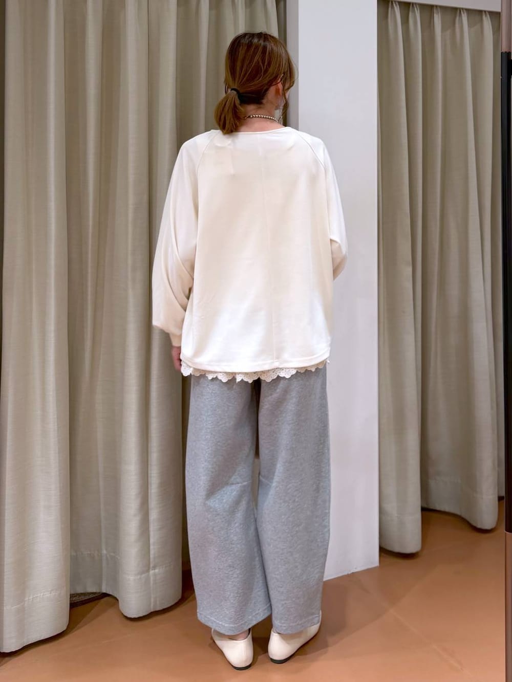 ホワイト系のパンプス、ホワイト系のタンクトップ、グレー系のスウェットパンツを着用したレディースの春コーディネートの4枚目の写真