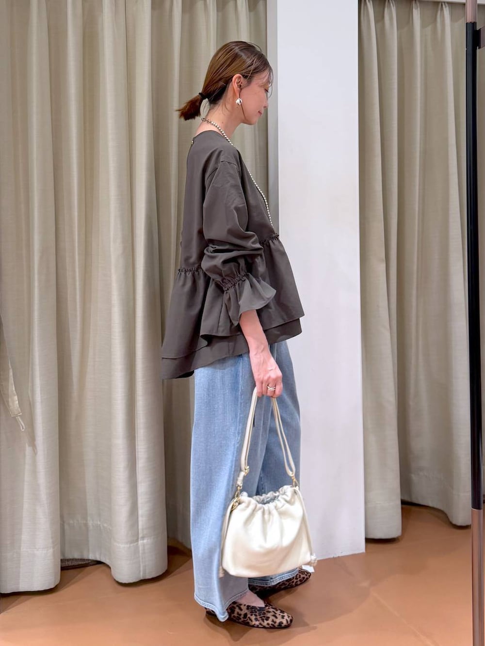 ホワイト系のハンドバッグ、ブルー系のデニムパンツ、ブラウン系のシャツ/ブラウスを着用したレディースの冬コーディネートの5枚目の写真