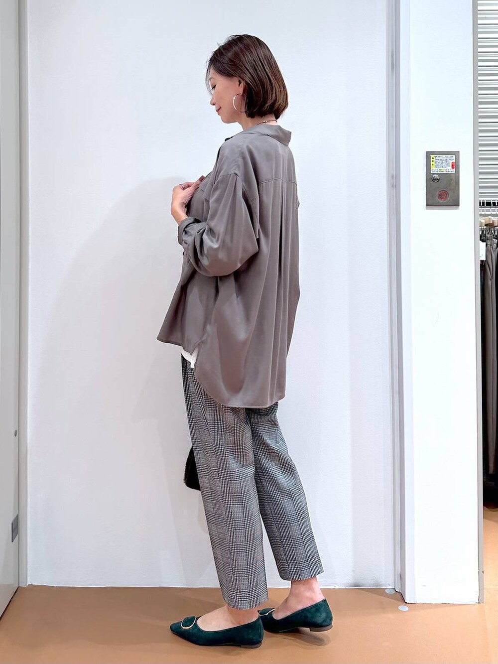 グレー系のシャツ/ブラウス、ブラック系のその他パンツ、グリーン系のパンプスを着用したレディースの秋コーディネートの3枚目の写真