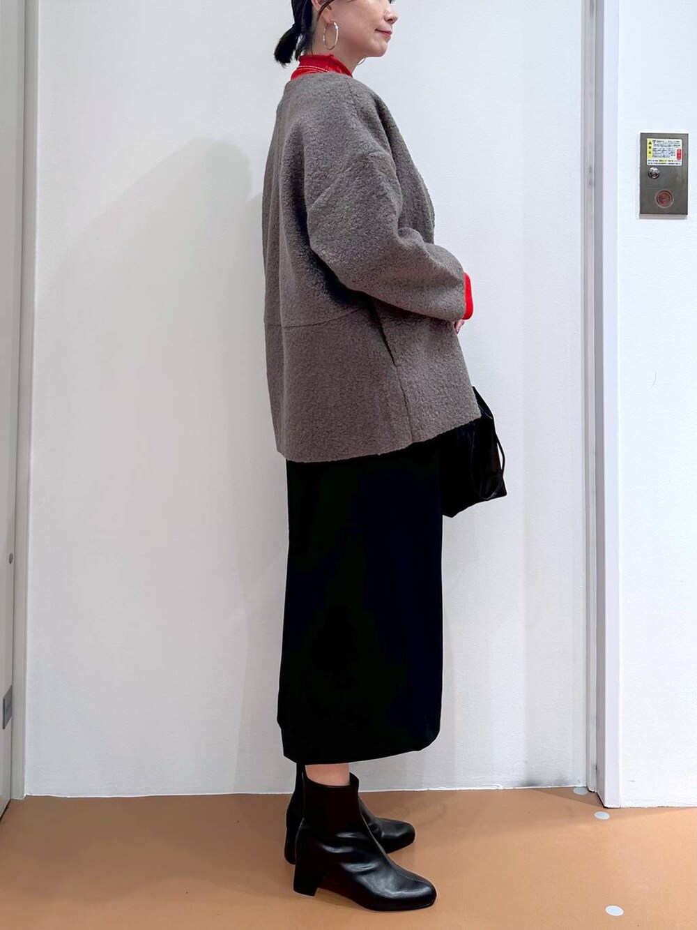 ブラック系のジャンパースカート、ブラック系のブーツ、ブラウン系のノーカラージャケットを着用したレディースの秋コーディネートの7枚目の写真