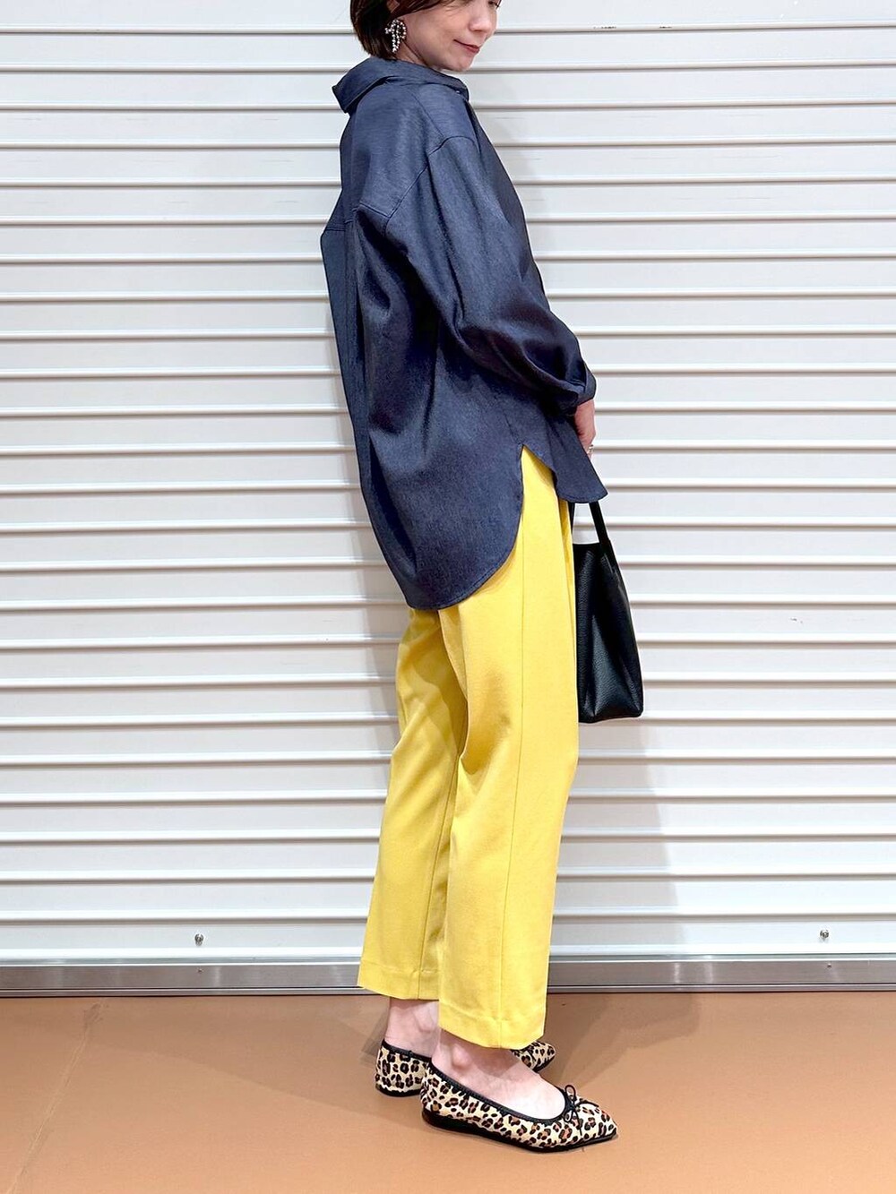 イエロー系のその他パンツ、ブラック系のハンドバッグ、ブラウン系のパンプスを着用したレディースの夏コーディネートの6枚目の写真