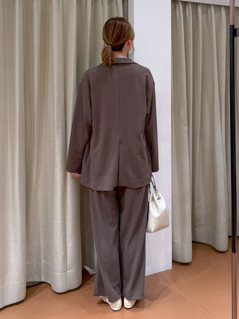 ブラウン系のその他パンツ、ホワイト系のパンプス、ホワイト系のTシャツ/カットソーを着用したレディースの春コーディネートの5枚目の写真