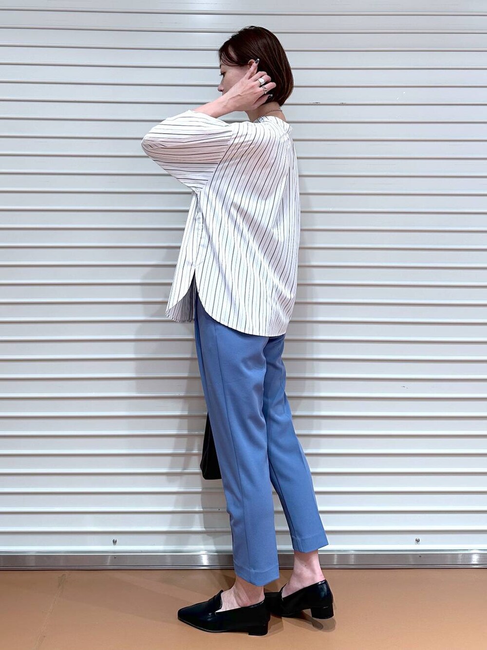 ブルー系のその他パンツ、ブラック系のハンドバッグ、ブラック系のローファーを着用したレディースの秋コーディネートの3枚目の写真